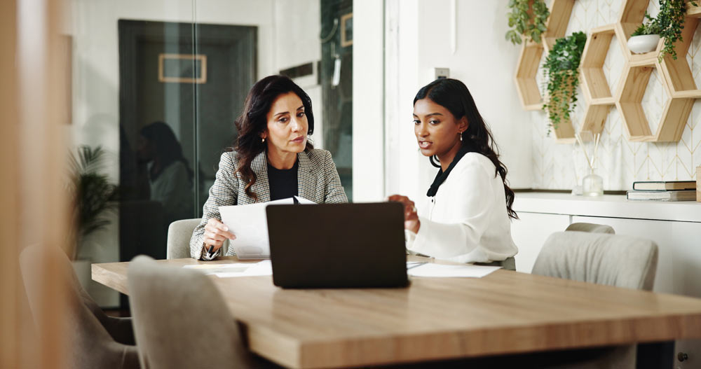 Två kvinnor sitter i ett möte